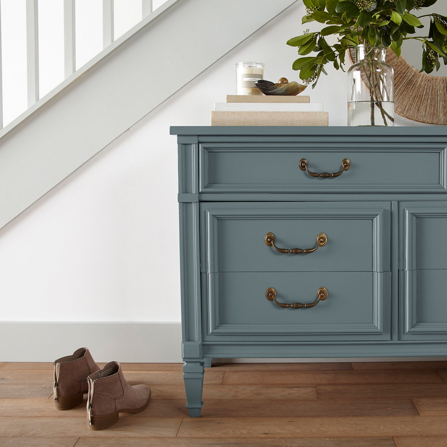 A grayed out blue door and cabinet paint named storm chaser shown painted on entryway cabinet