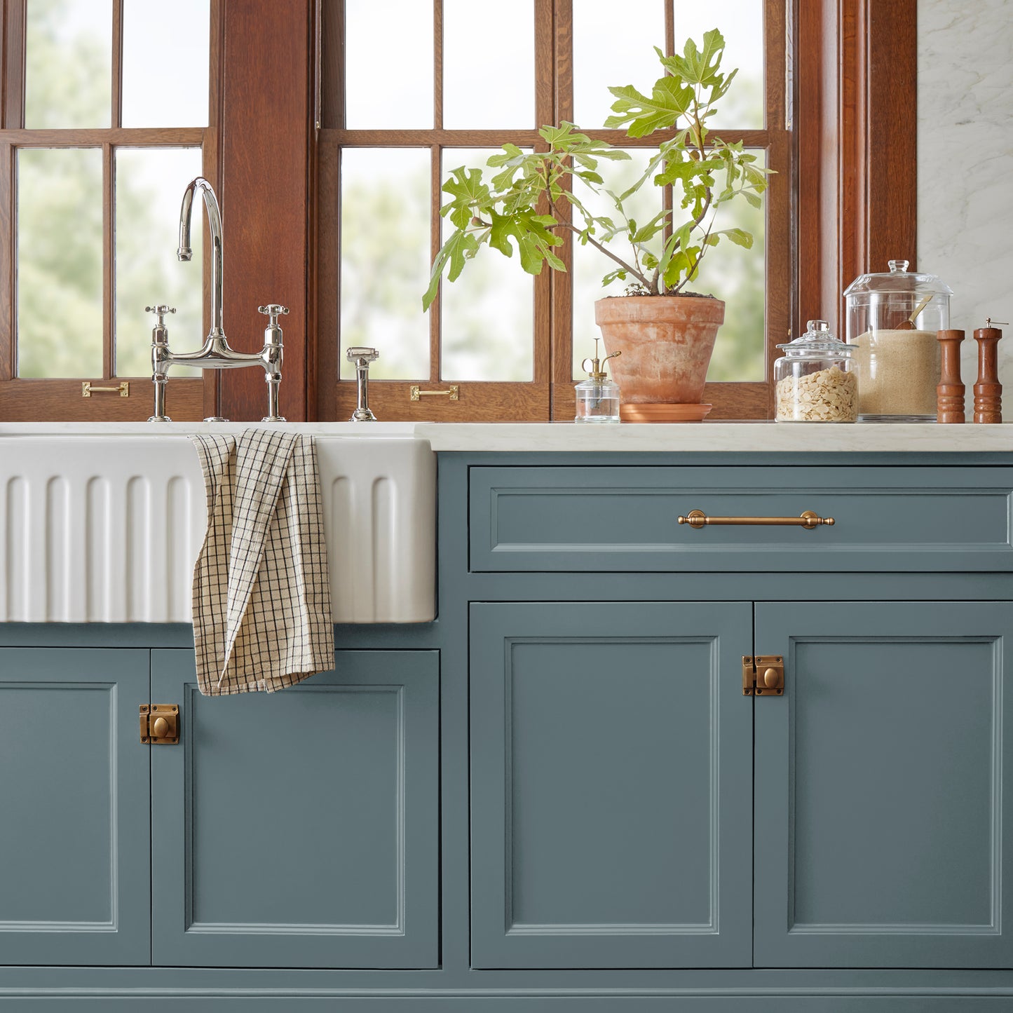 A grayed out blue door and cabinet paint named storm chaser shown painted on kitchen cabinet