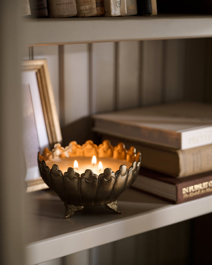 Antique Brass Footed Candle Bowl lit on shelf