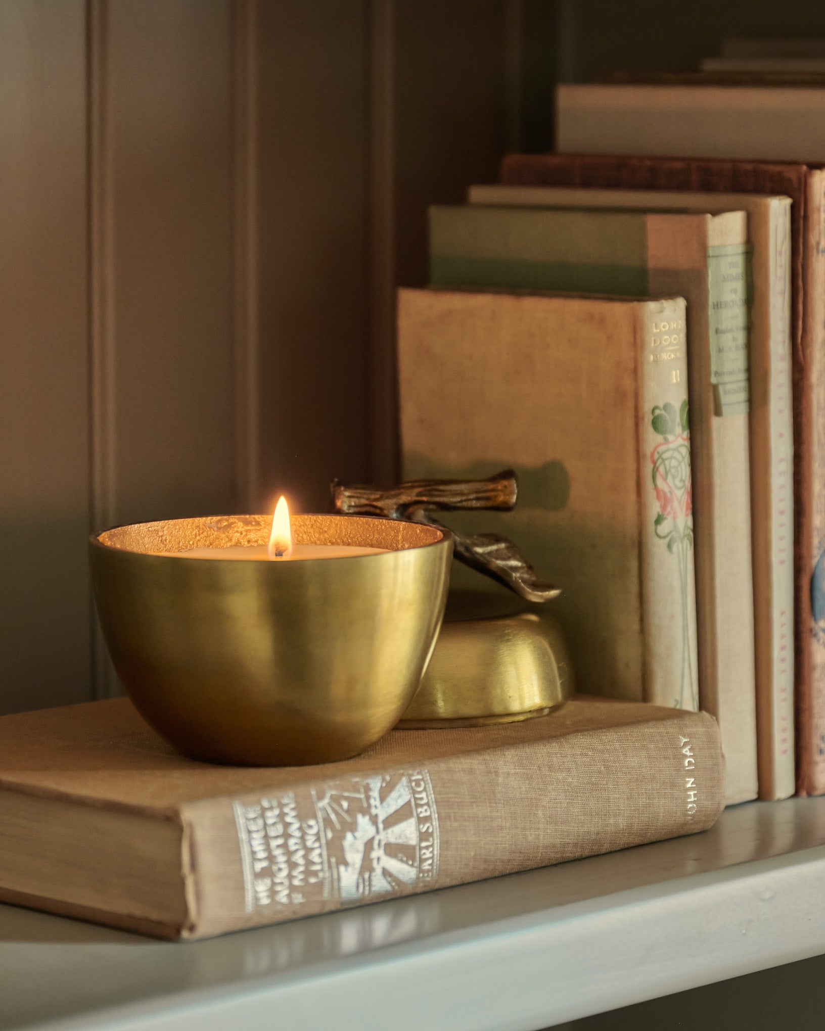 Antique Brass Apple Candle lit up on shelf