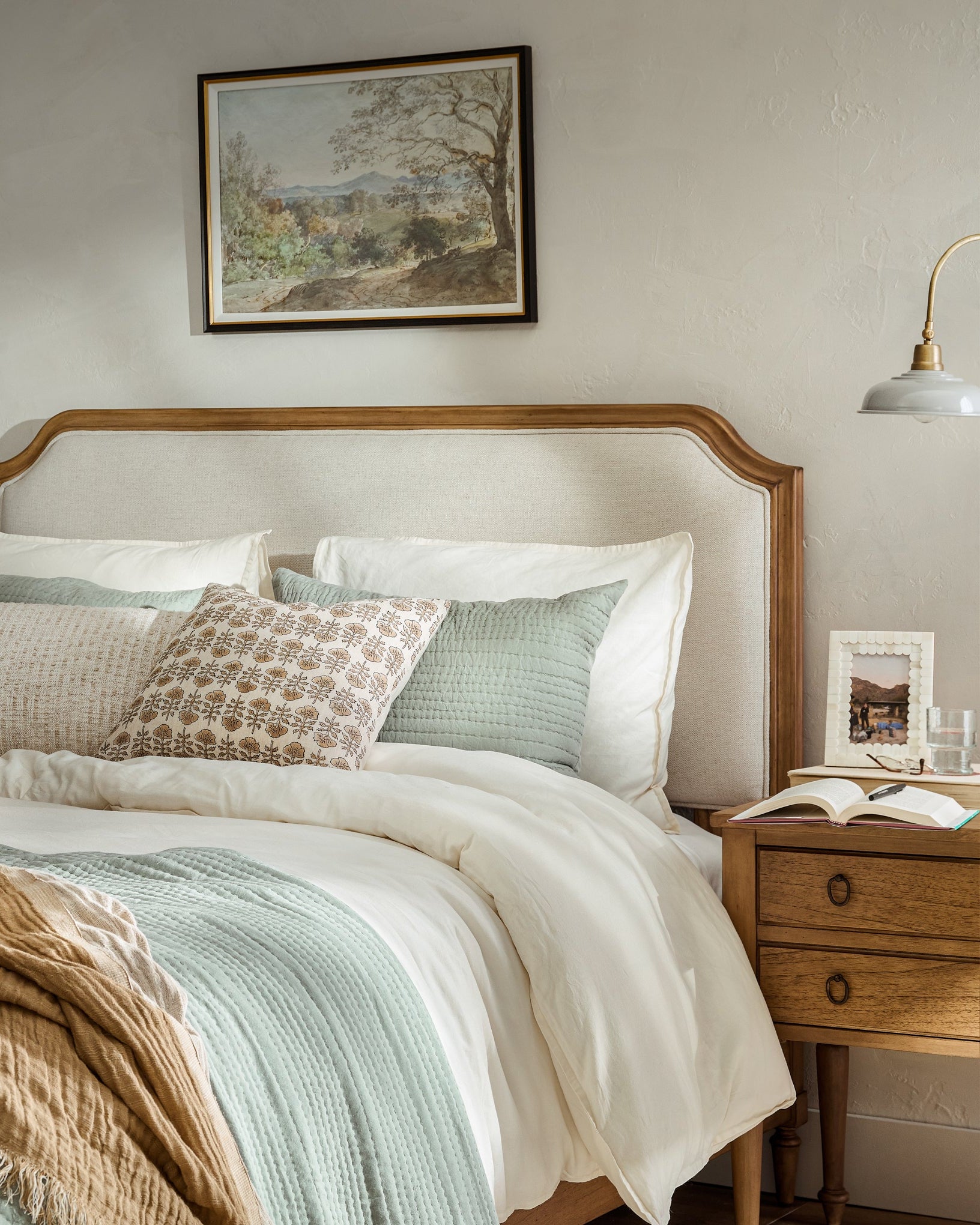 Corinne Upholstered Bed with bedding in a bedroom