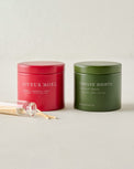 Magnolia Joyeux Noel and Twelve Nights Candle Tin Bundle shown with matches