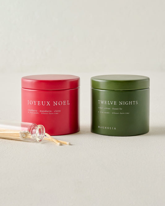 Magnolia Joyeux Noel and Twelve Nights Candle Tin Bundle shown with matches