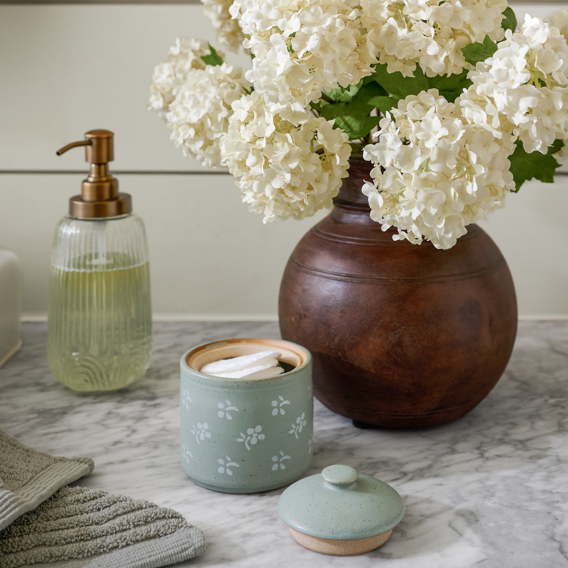 Theo Aged Wood Vase shown on bathroom counter