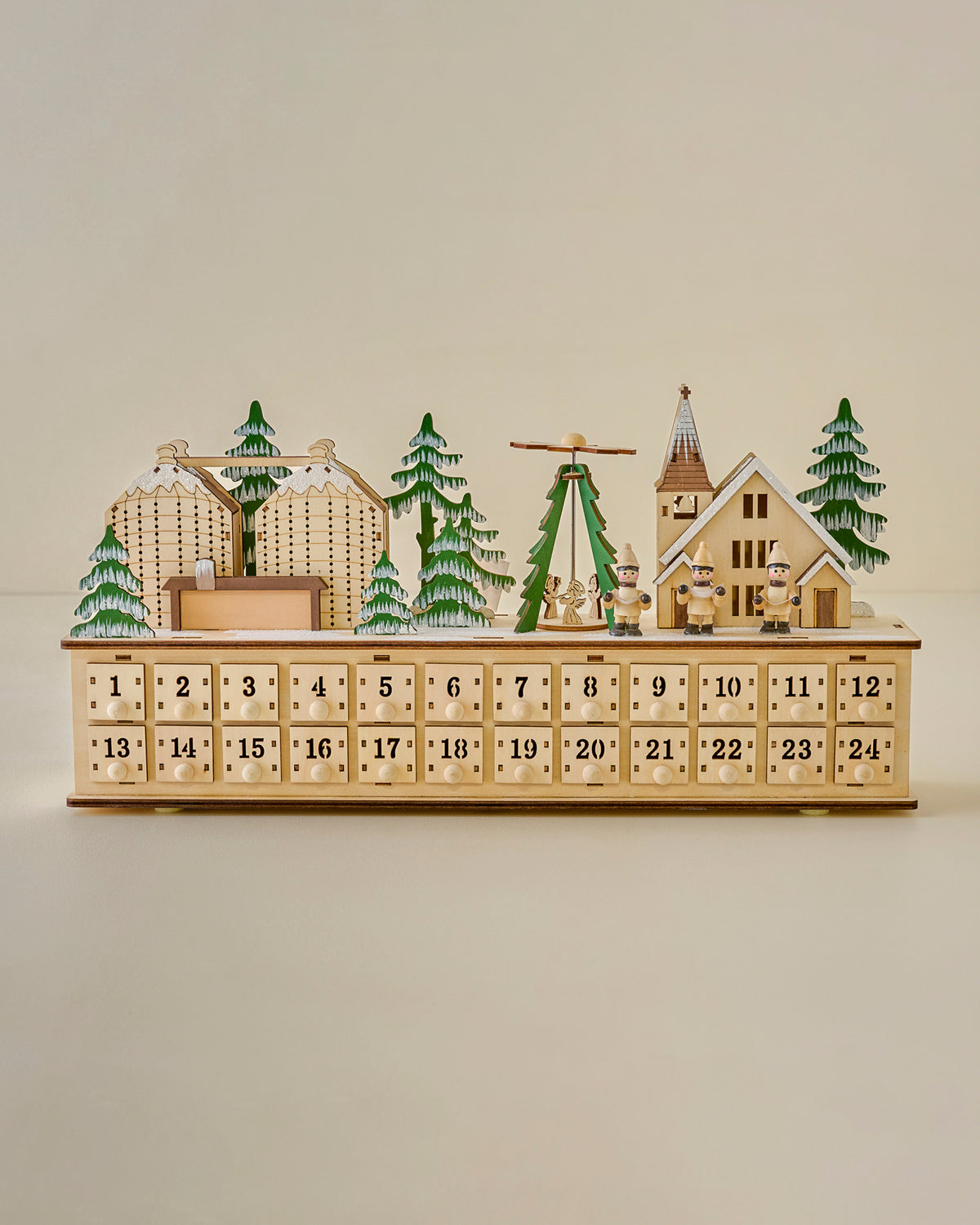 Wooden advent calendar with Christmas village scene on a beige background