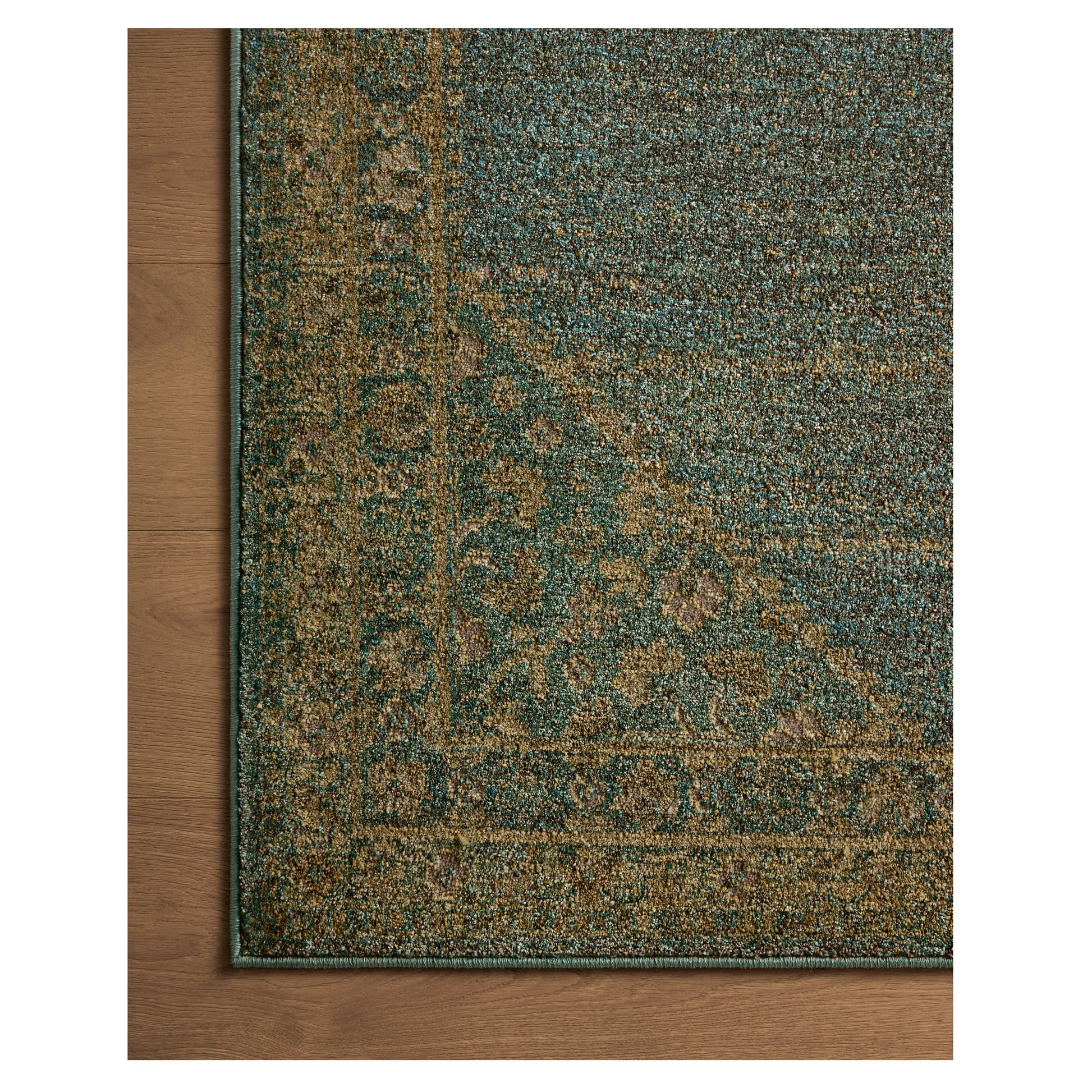 Mona Aqua Wheat Rug close up of corner on wood floor