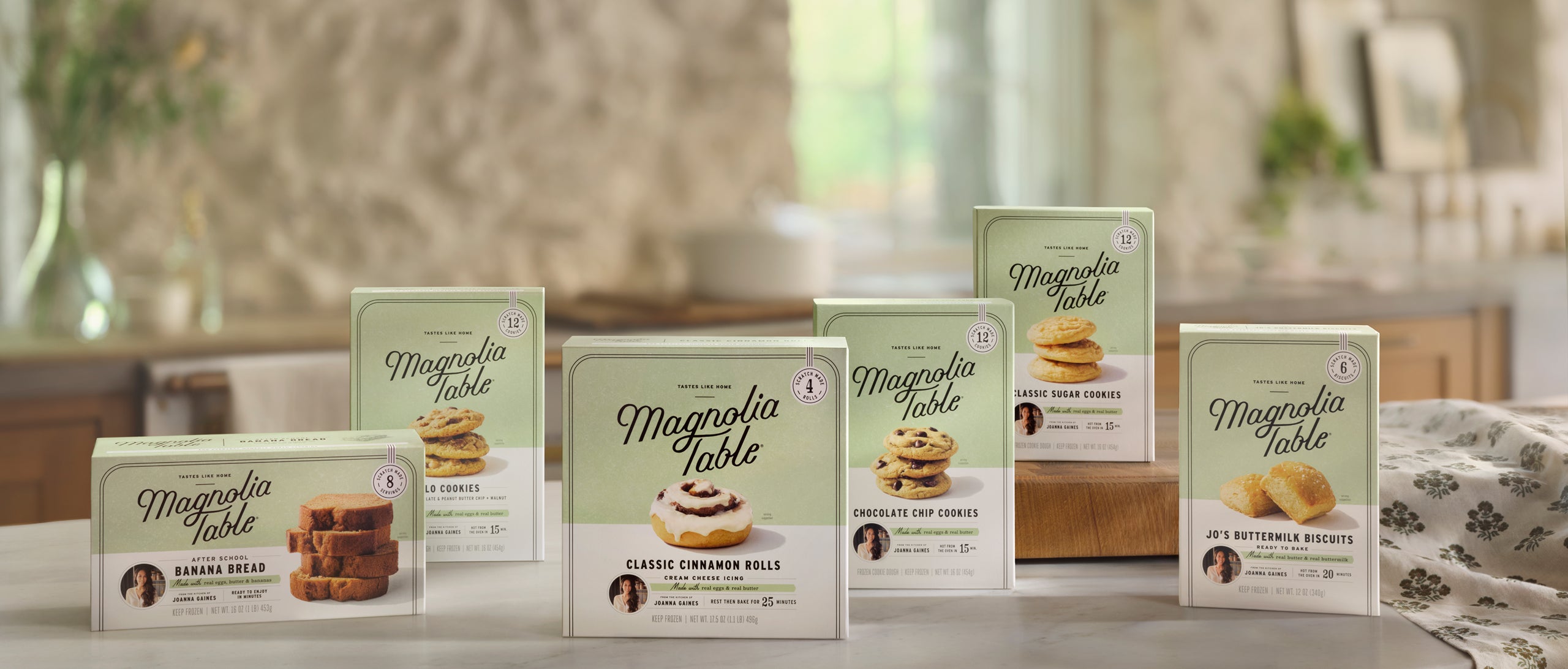 Collection of Magnolia Table Frozen Baked Goods product packages on a kitchen counter.