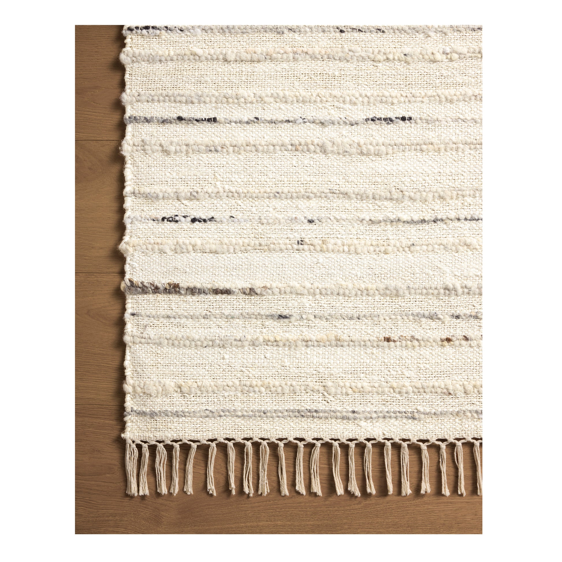Nico Ivory Stone Rug close up of corner on wood floor