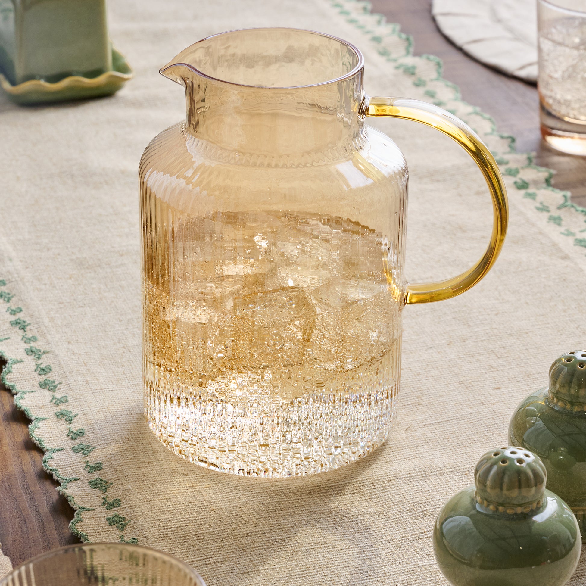 Peach Ribbed Glass Pitcher shown on table filled with water
