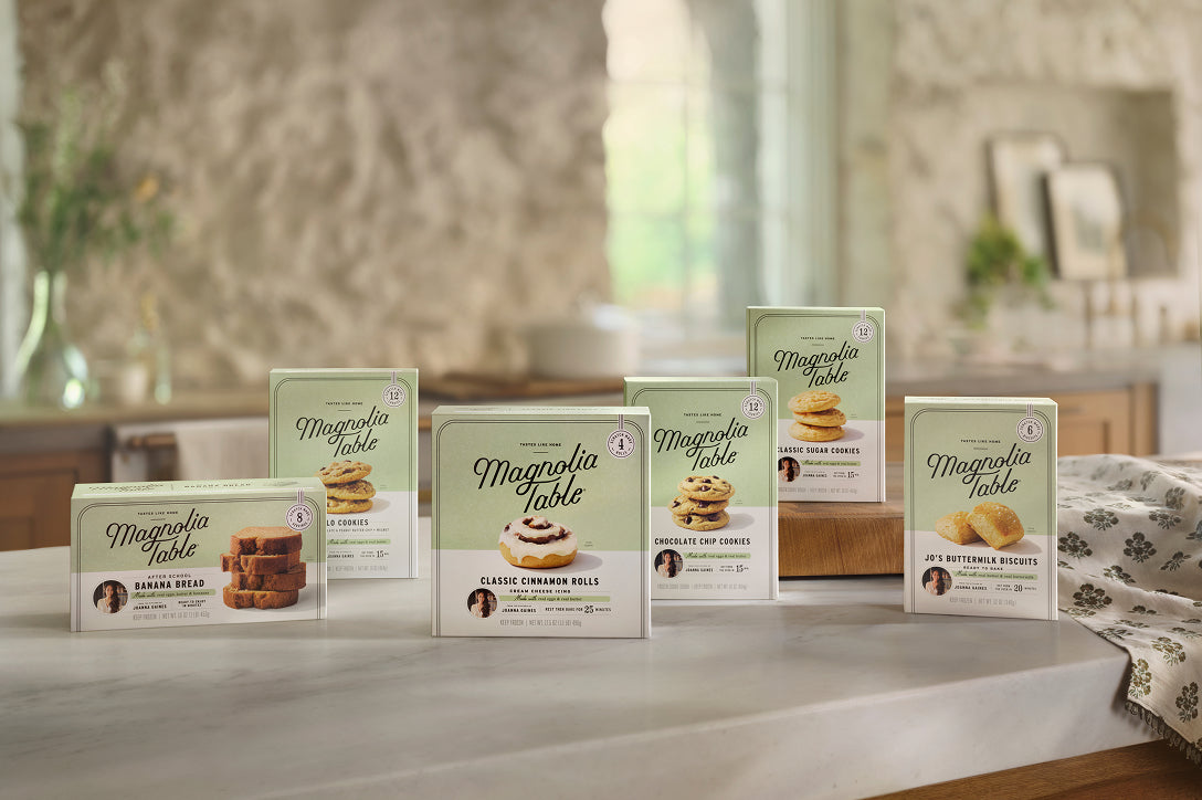 Multiple boxes of Frozen Magnolia Table products on a kitchen counter.