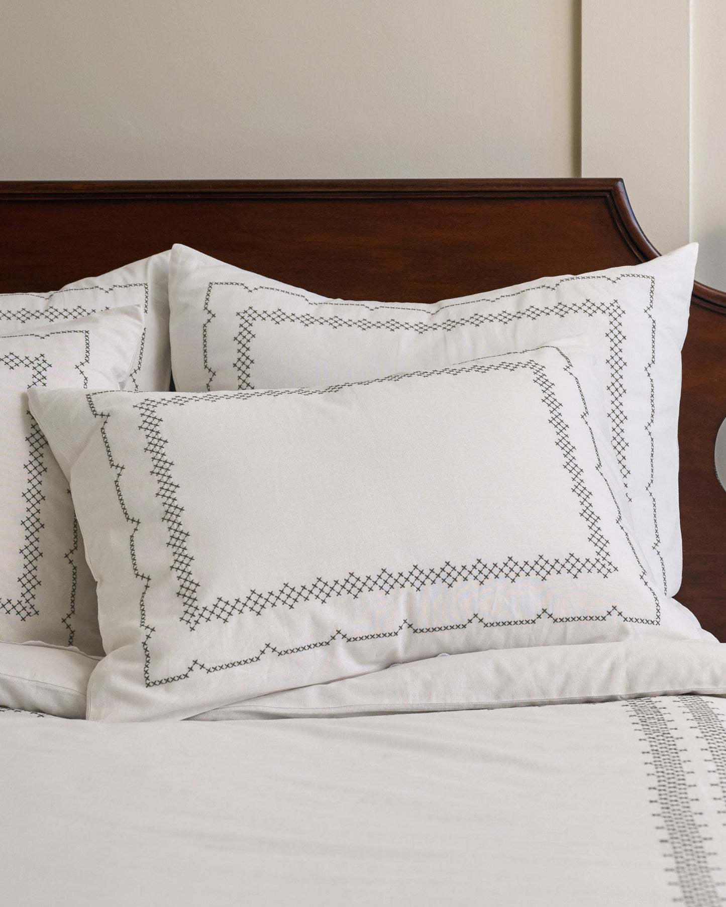 Daphne Cross-Stitch Sham Queen/King shown on bed