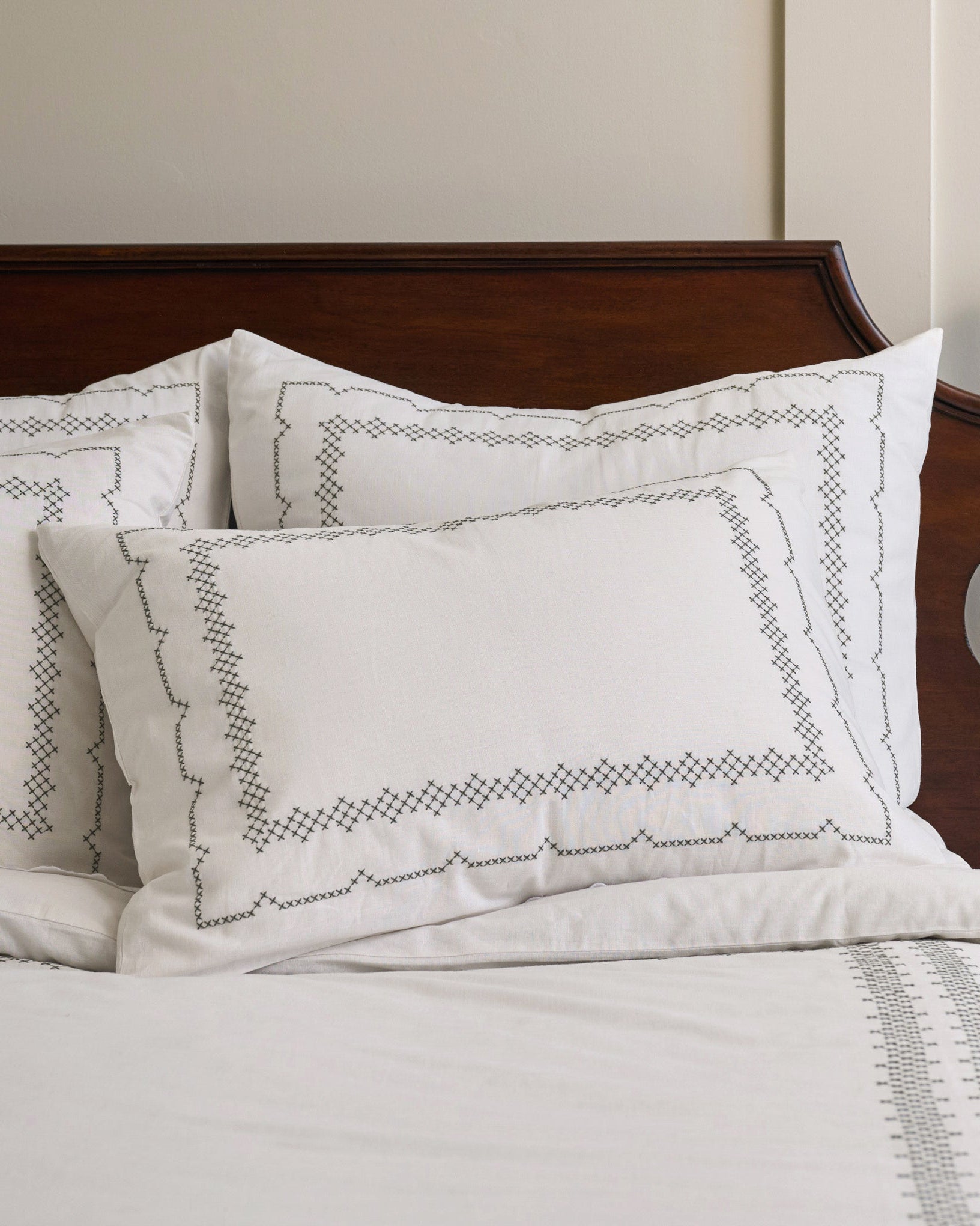 Daphne Cross-Stitch Sham Queen/King shown on bed
