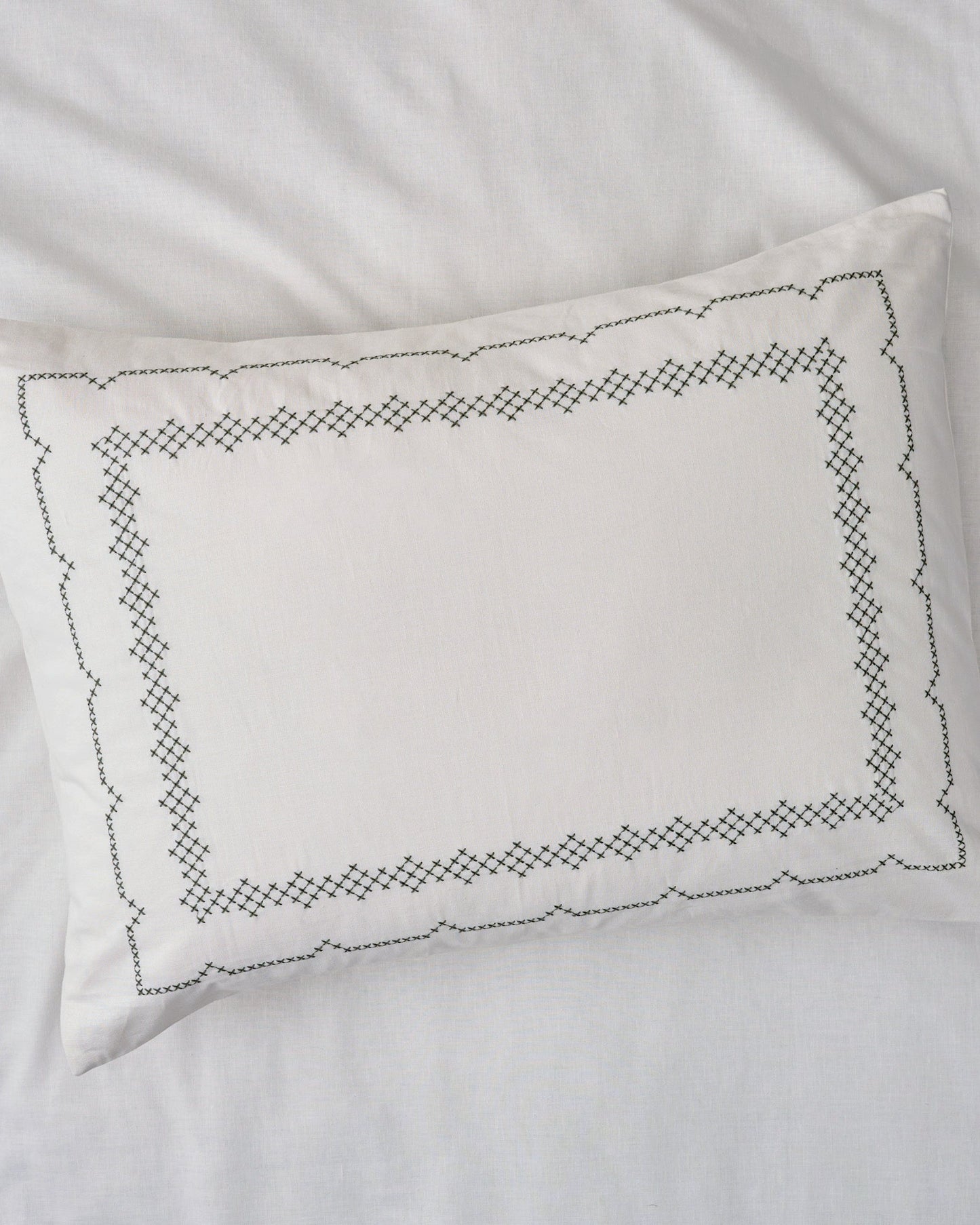 Daphne Cross-Stitch Sham queen/king shown on bed