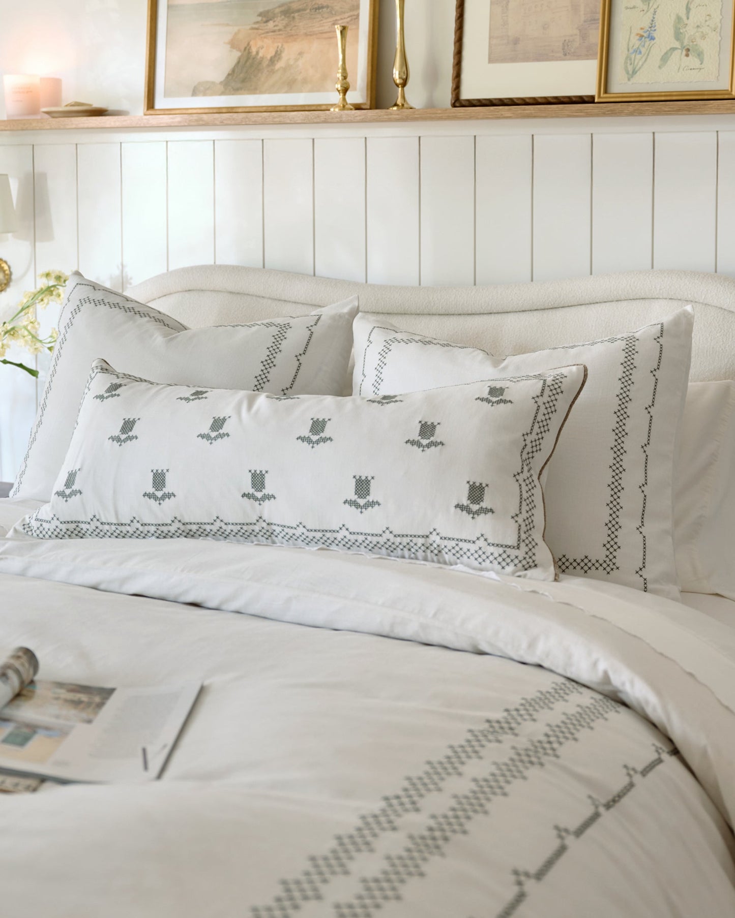 Daphne Cross-Stitch Sham shown on bed 
