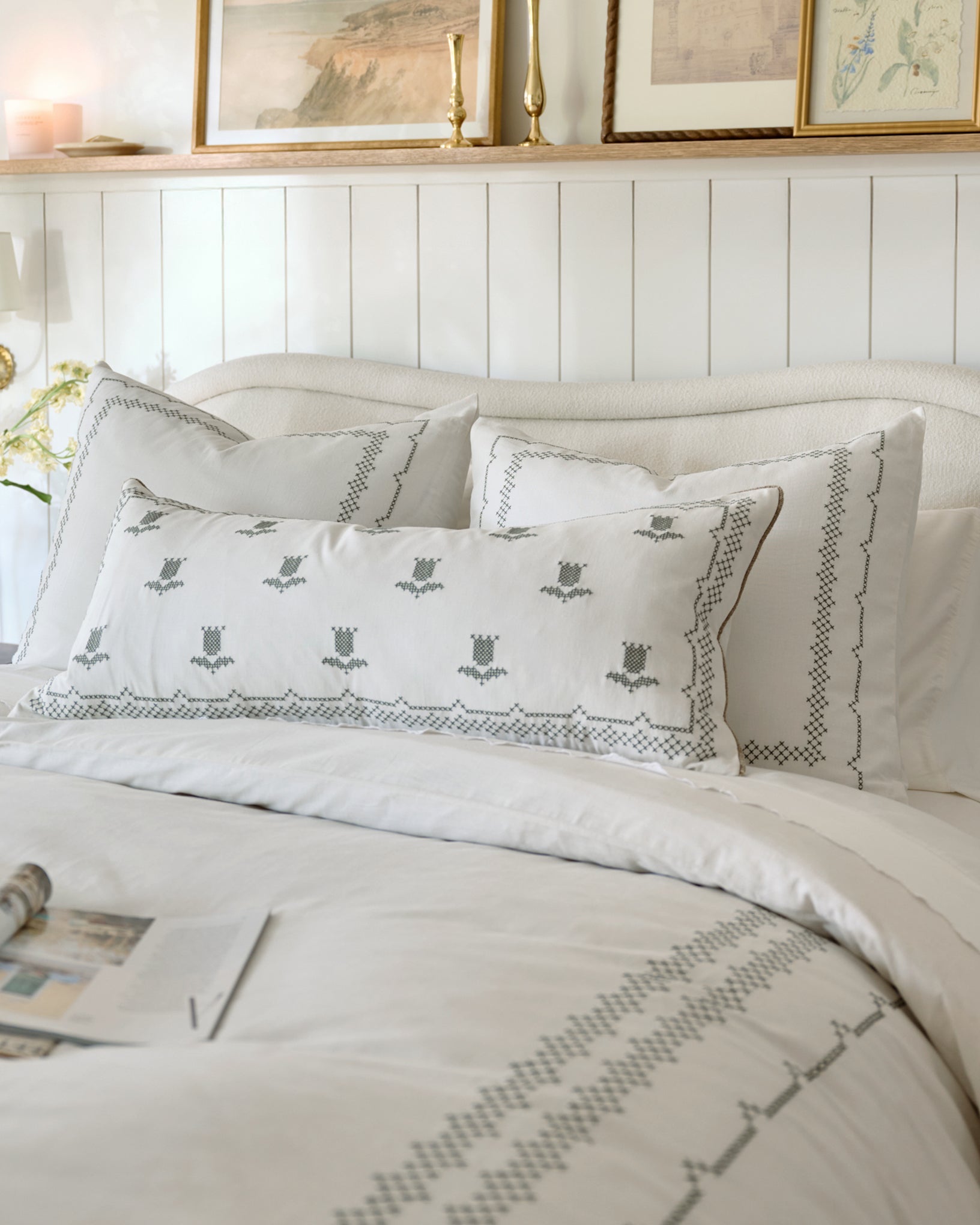 Daphne Cross-Stitch Sham shown on bed 