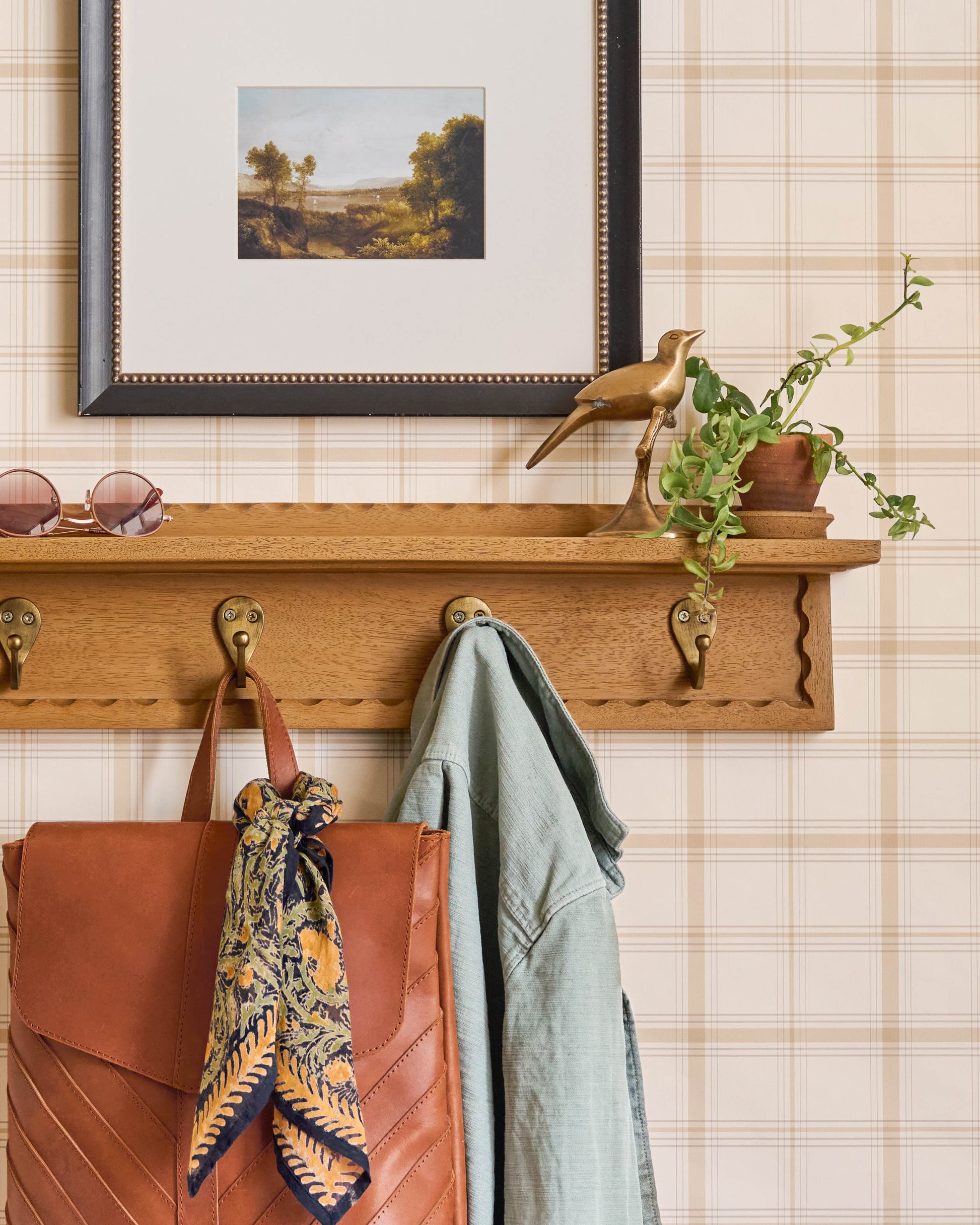 Wade Wood Wall Shelf with Hooks shown on a wall
