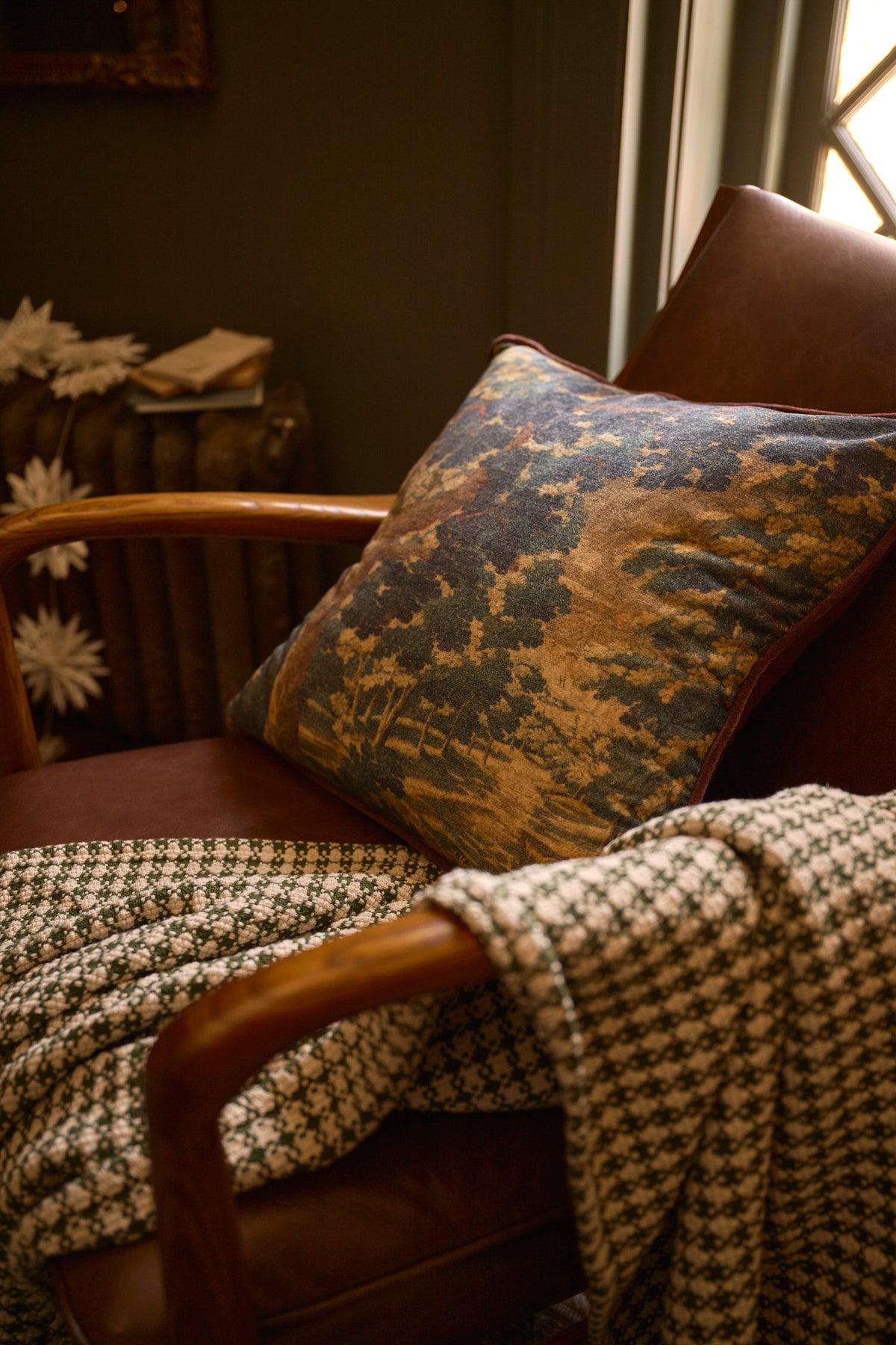Evergrove Printed Velvet Pillow with Settle in Plaid throw on chair