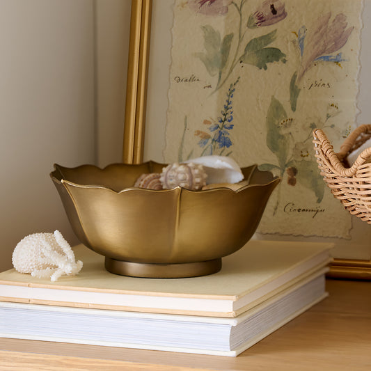 Ellie Antiqued Brass Decorative Bowl styled on top of books on shelf
