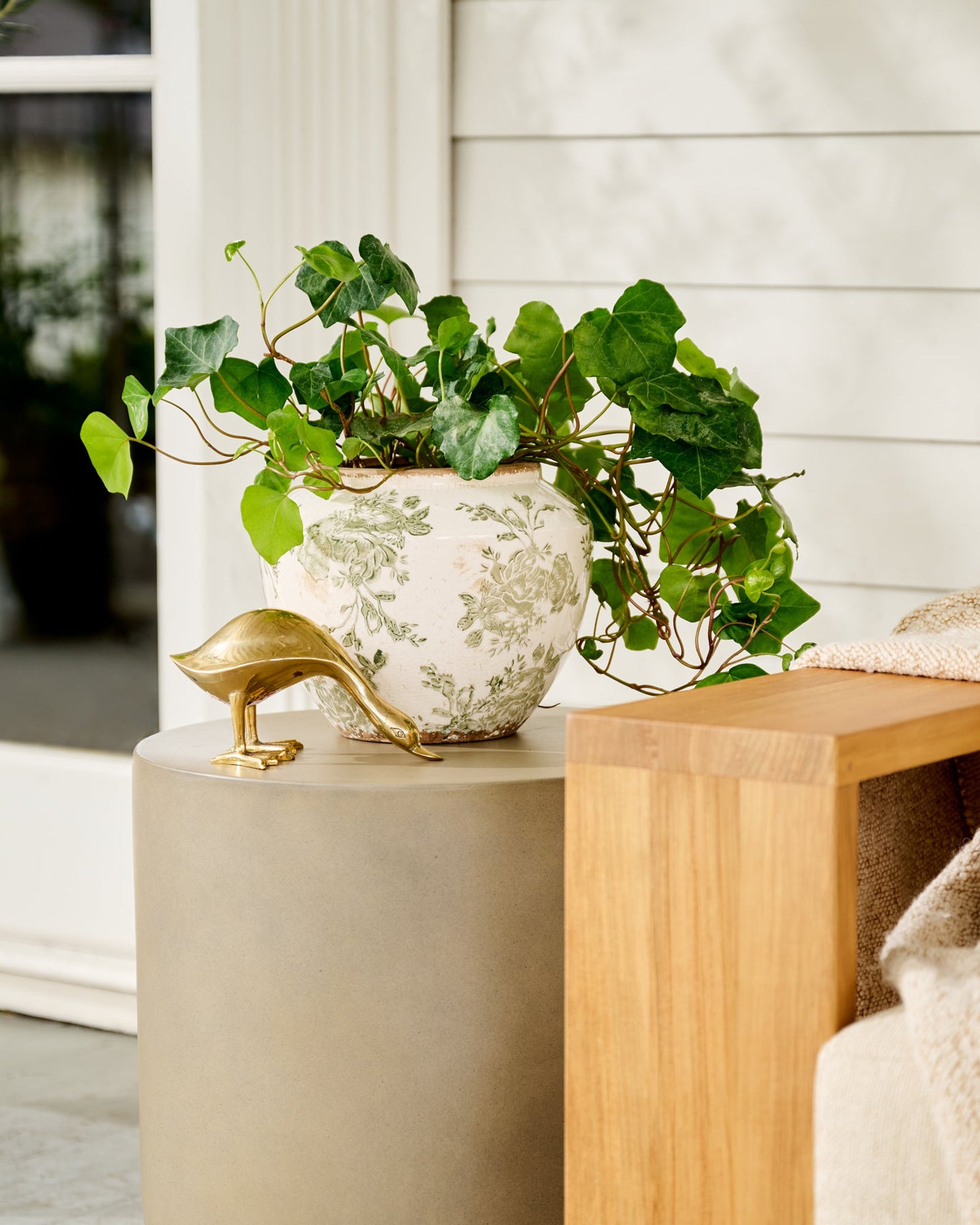 Small Green and White Distressed Floral Vase shown outside