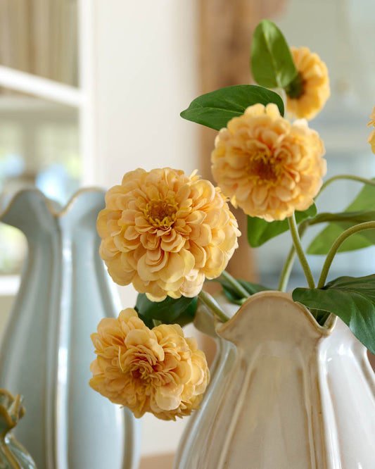 Yellow flowers in a white vase with a blurred background