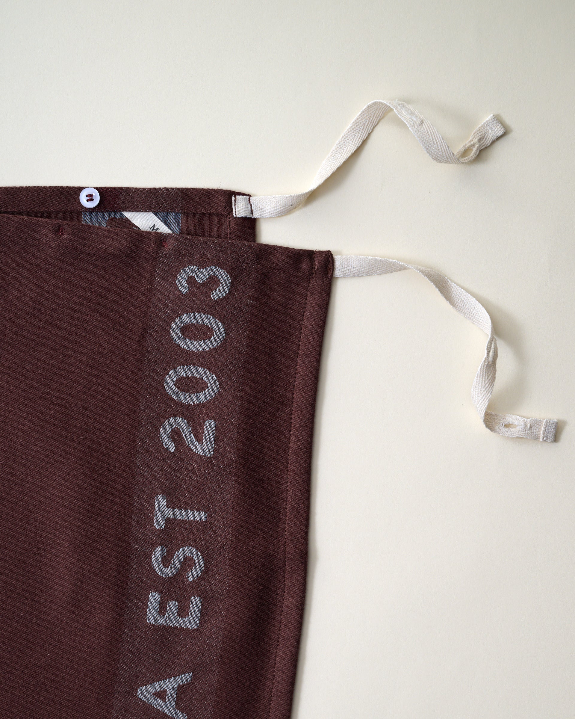 Magnolia Est. Convertible Tea Towel Apron - Brunette close up of ties
