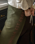 Magnolia Est. Convertible Tea Towel Apron - Capers being tied around a waist like an apron