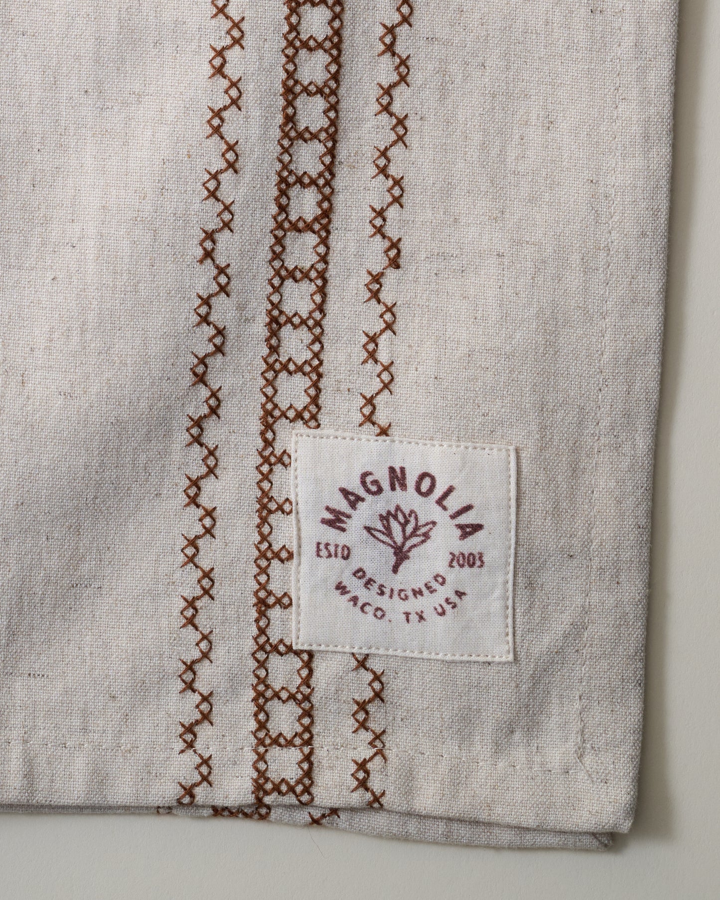 Natural Embroidered Stripe Tea Towel close up of logo