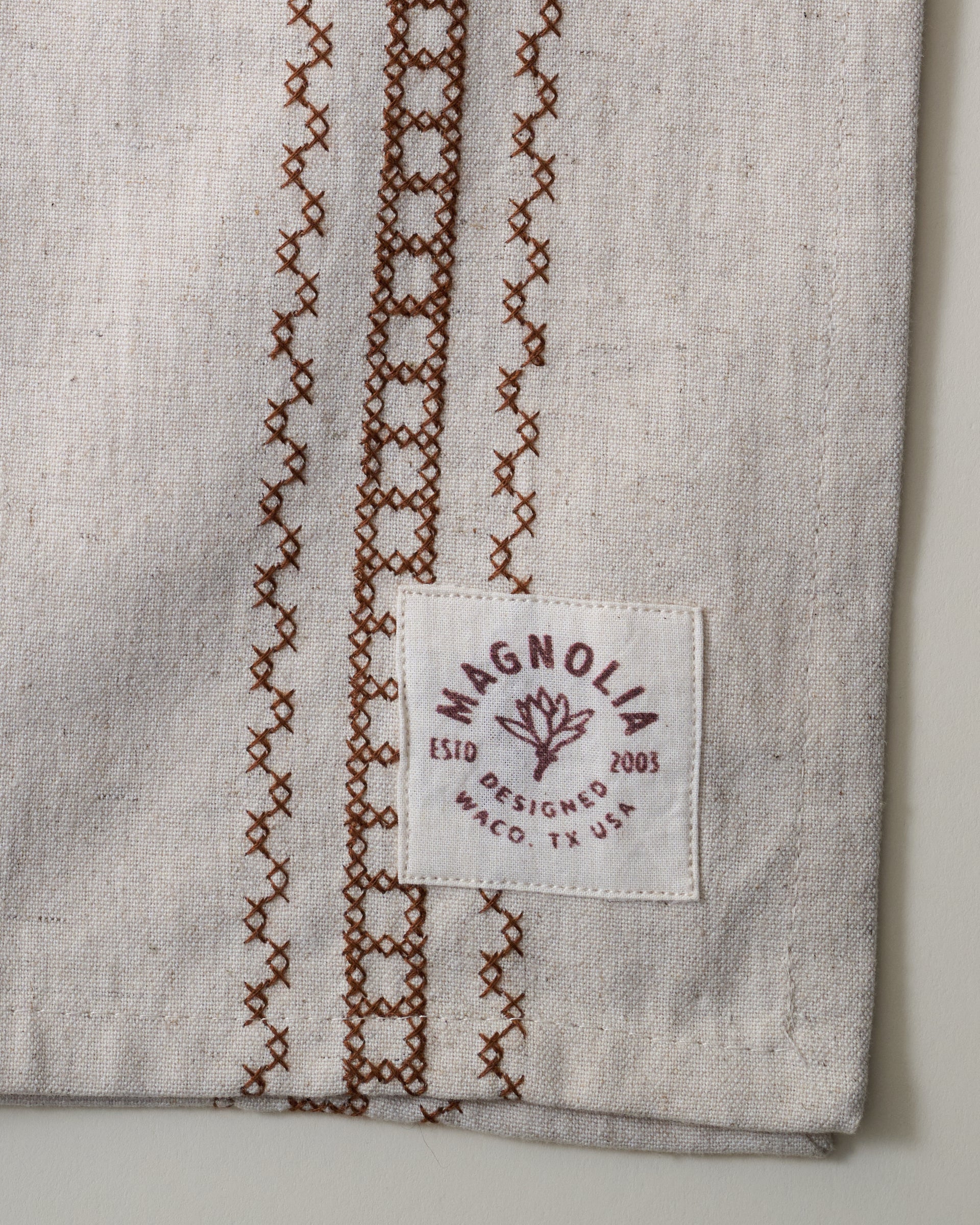 Natural Embroidered Stripe Tea Towel close up of logo