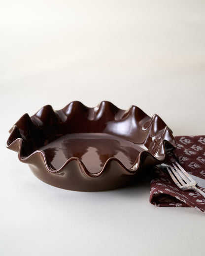 Chocolate Scalloped Pie Dish with tea towel and flatware