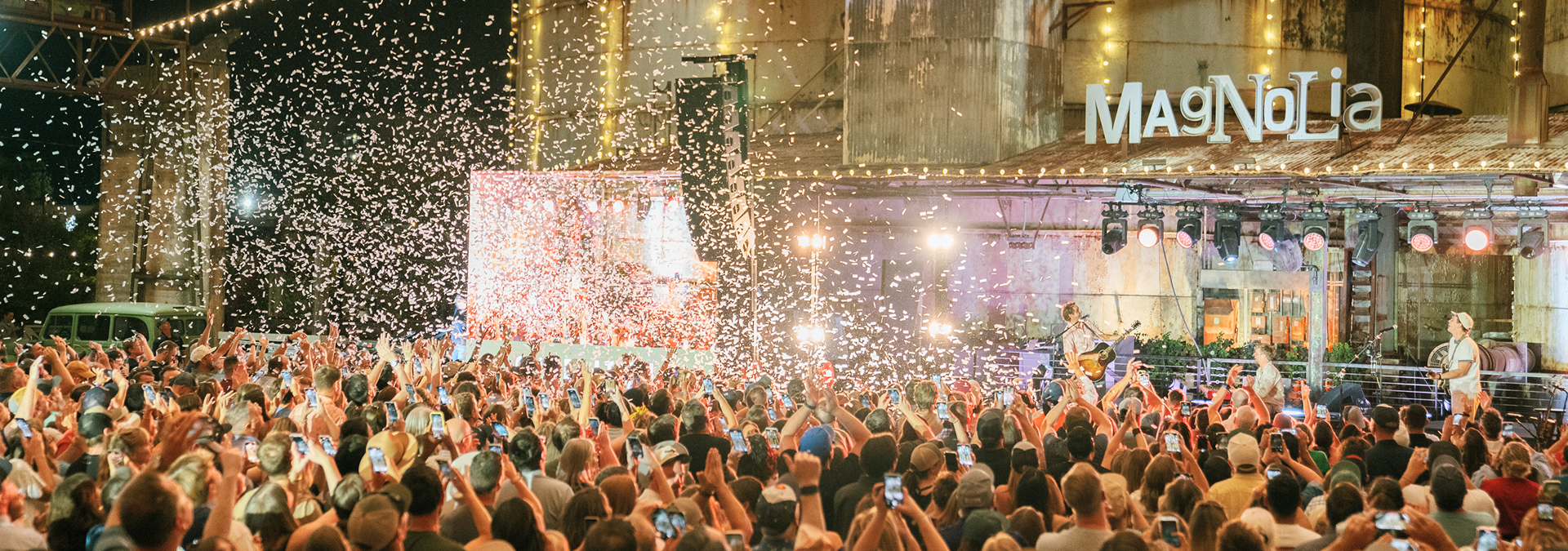 Large crowd gathered in front of a theater with confetti falling, featuring the Magnolia theater name.
