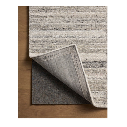 Rae Stone Ivory Rug close up of corner flipped back on wood floor