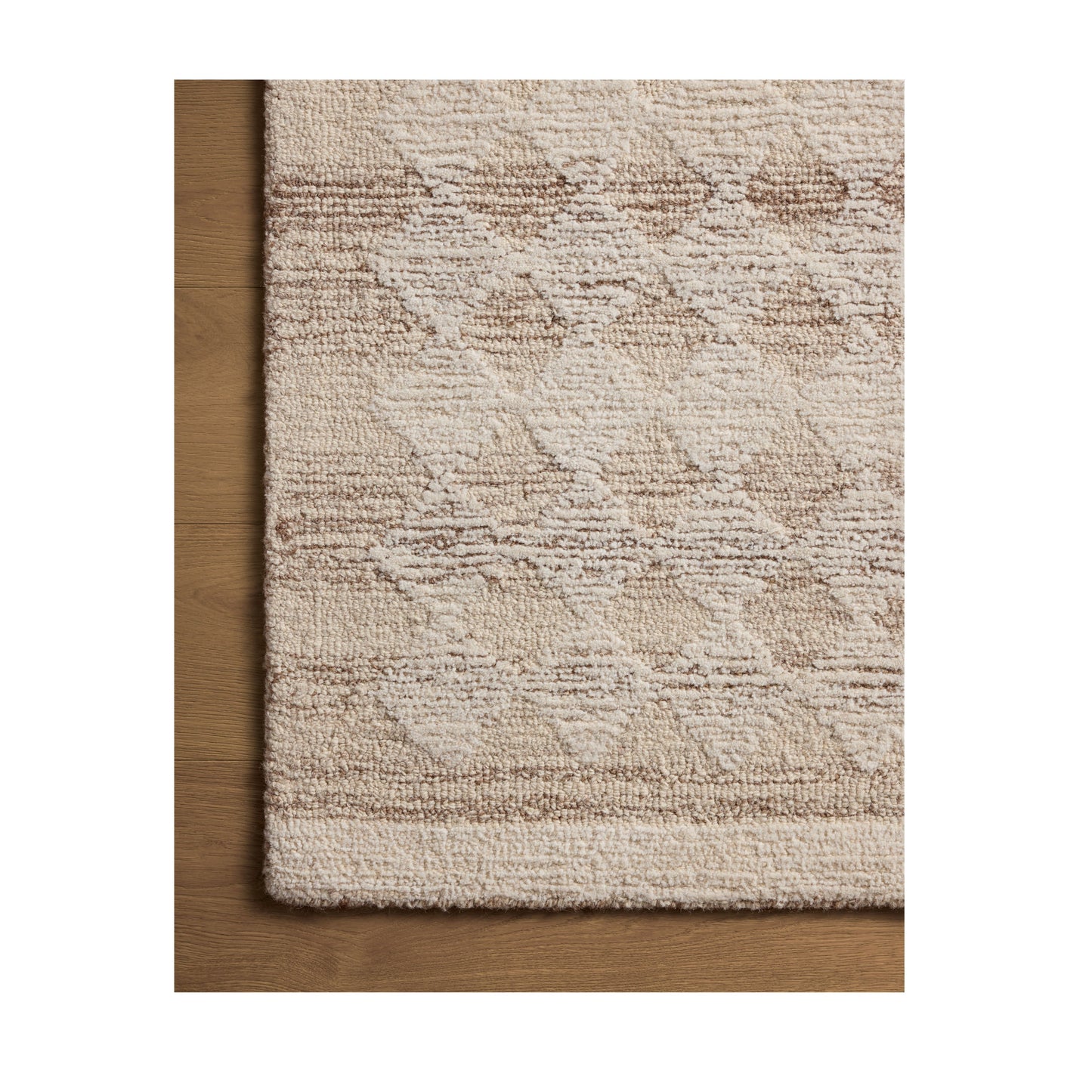 Rae Natural Ivory Rug close up of corner of rug on wood floor
