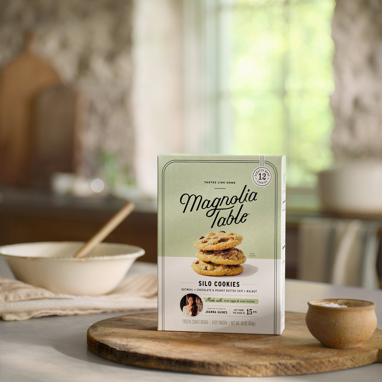 Box of Frozen Magnolia Table Silo Cookies on a table with a mixing bowl in the background.