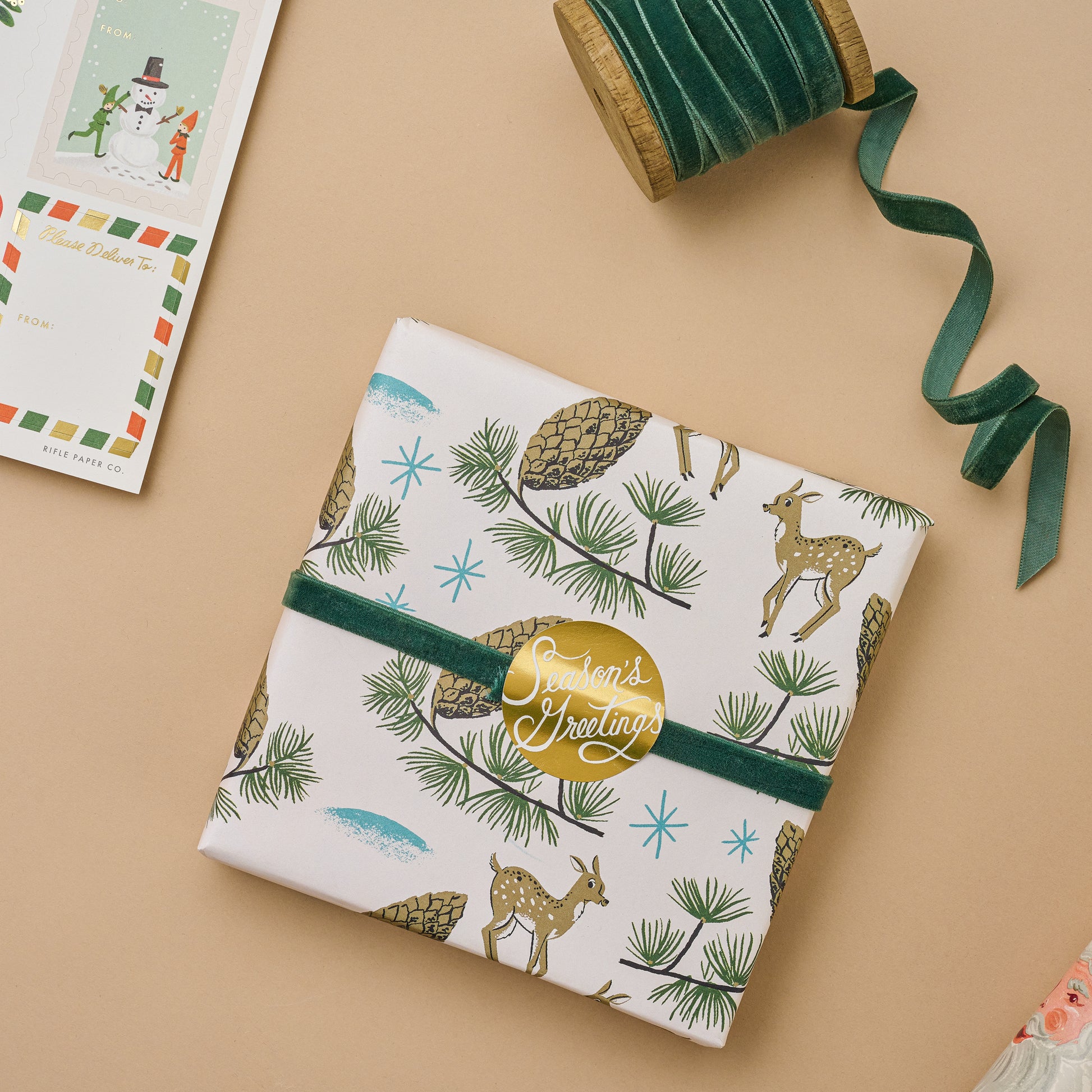 Deer and Pinecones Wrapping Paper Sheets wrapped on a box with green ribbon