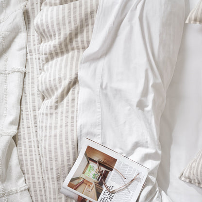 optic white textured cotton coverlet with a book on top