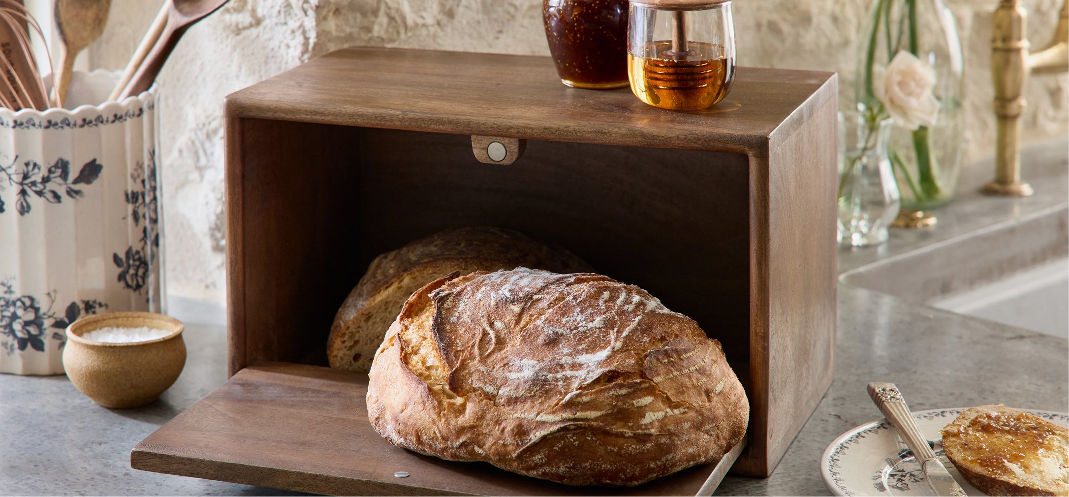 Wooden bread box with loaves of bread on a kitchen counter