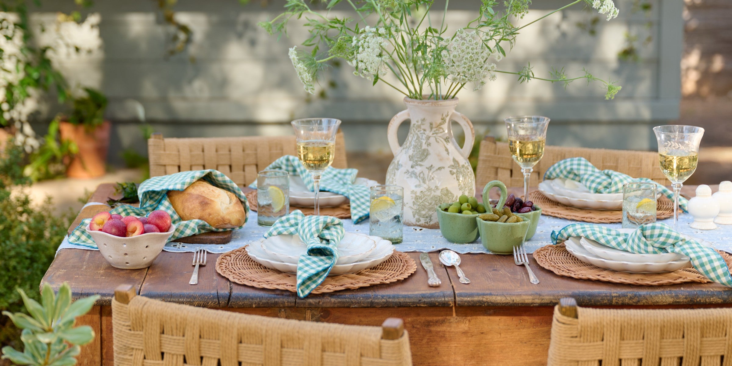 Elegant dining table setting with plates, glasses, and decorative elements.