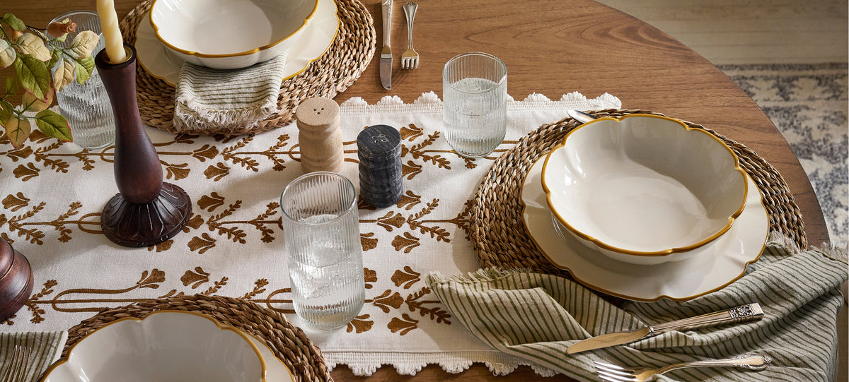 Elegant dining table setting with plates, glasses, and decorative elements.