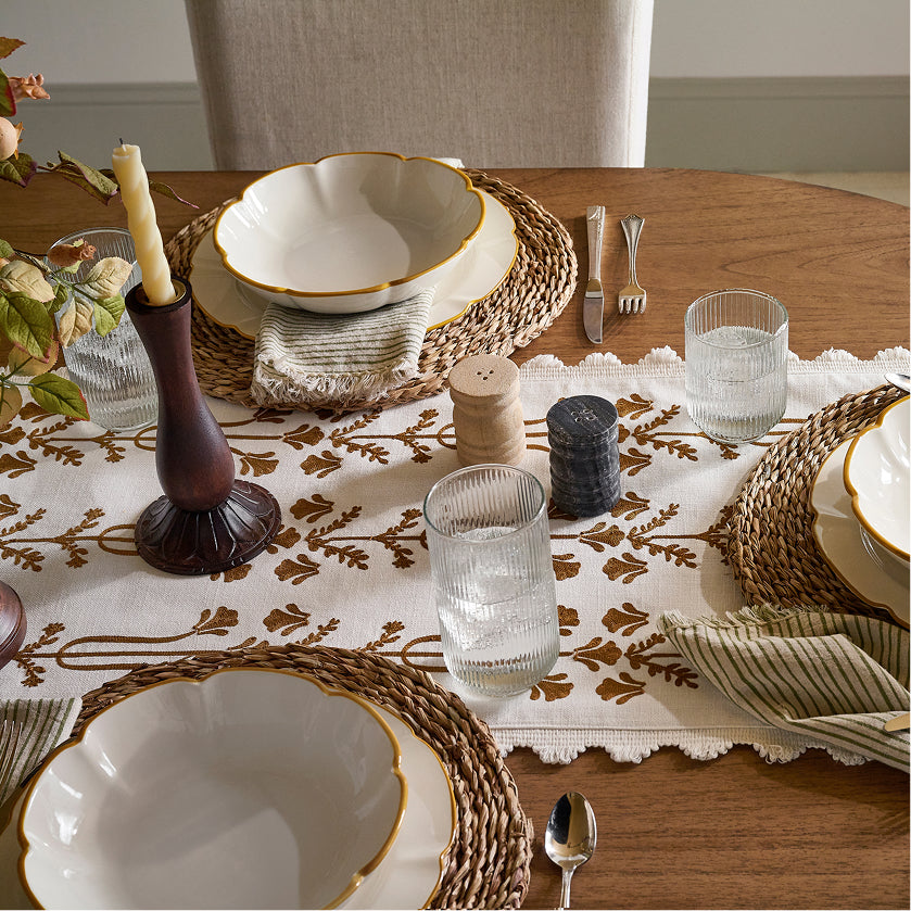 Elegant dining table setting with plates, glasses, and decorative elements.