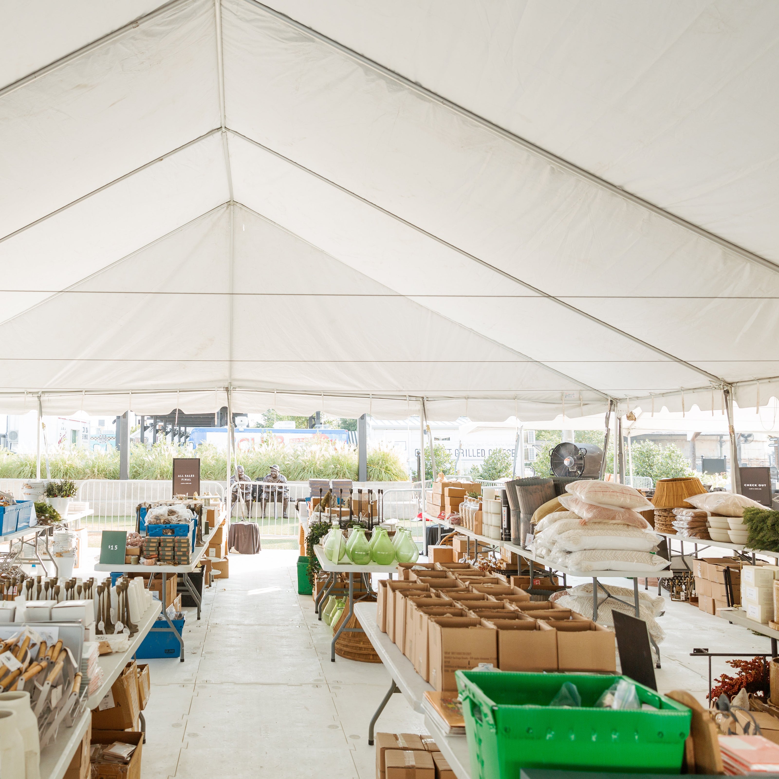 Large indoor tent with tables and chairs set up for an event or sale.