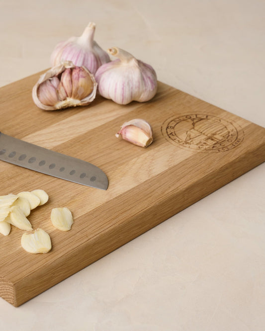 Magnolia Seal Cutting Board with chopped garlic on top 
