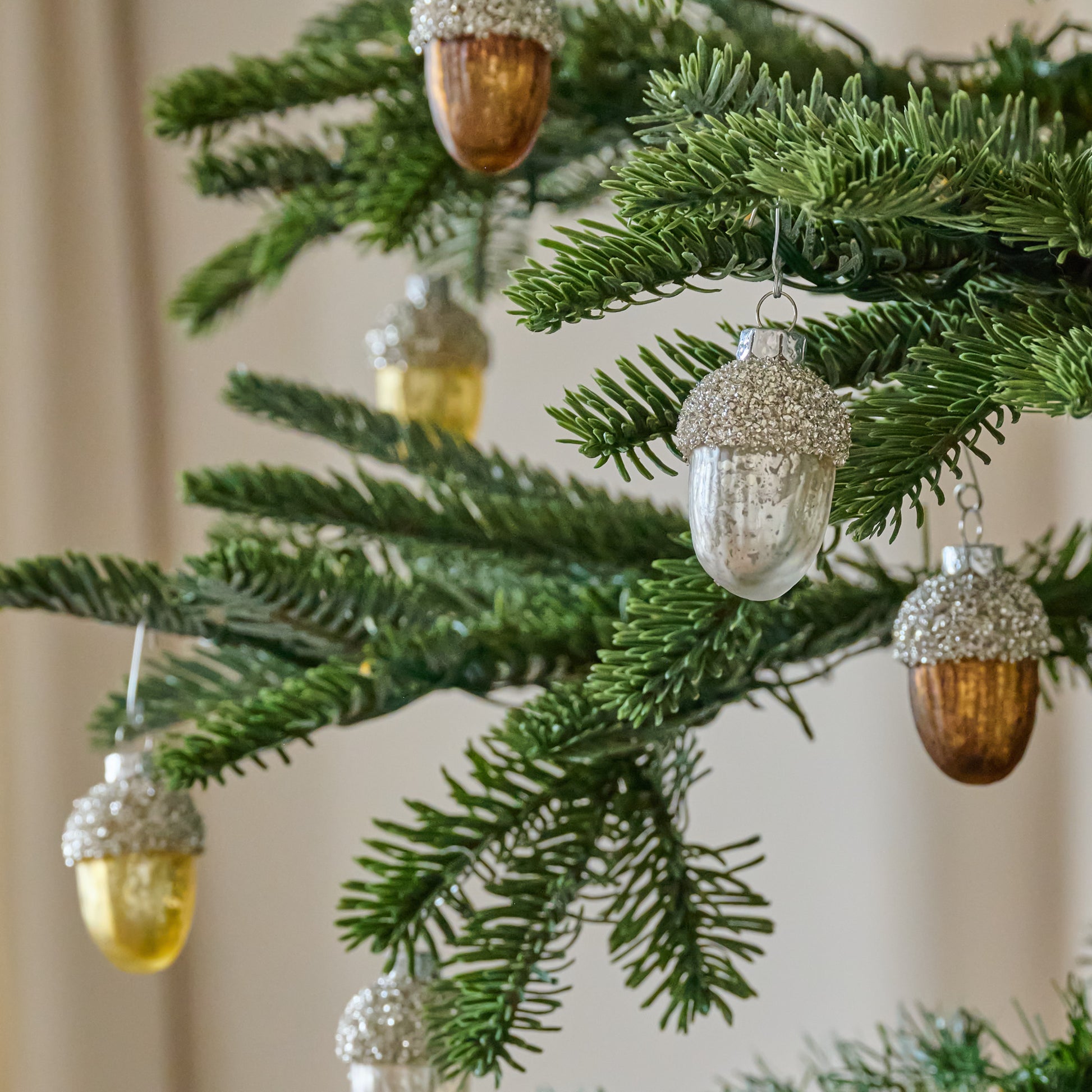 Glass Acorn Ornament, Set of 12 shown hung on tree