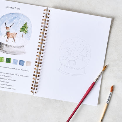 Winter Watercolor Workbook open with paintbrushes