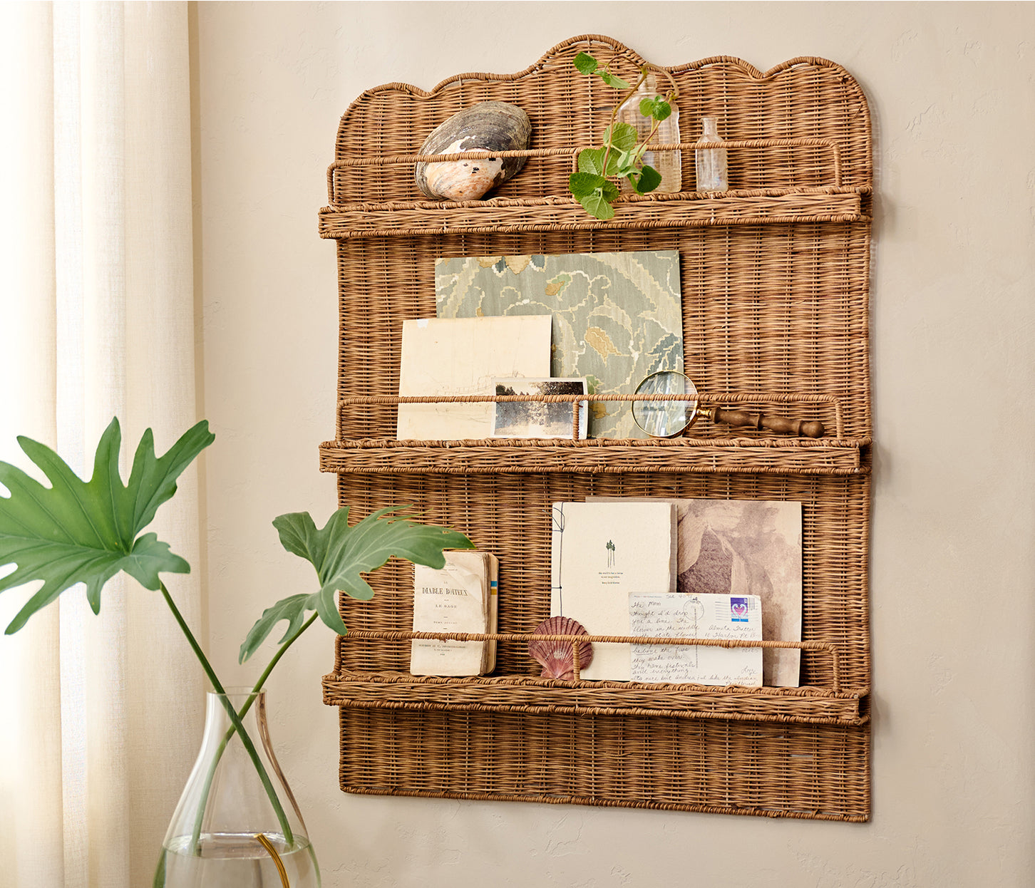 Wicker wall shelf with decorative items against a beige wall