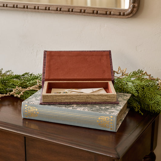 Vintage-Inspired Handcrafted Book Box with an open lid on a wooden surface with greenery
