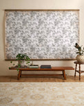 Oversized Heirloom Garden Tapestry in a room with wooden bench coffee table books and greenery plants