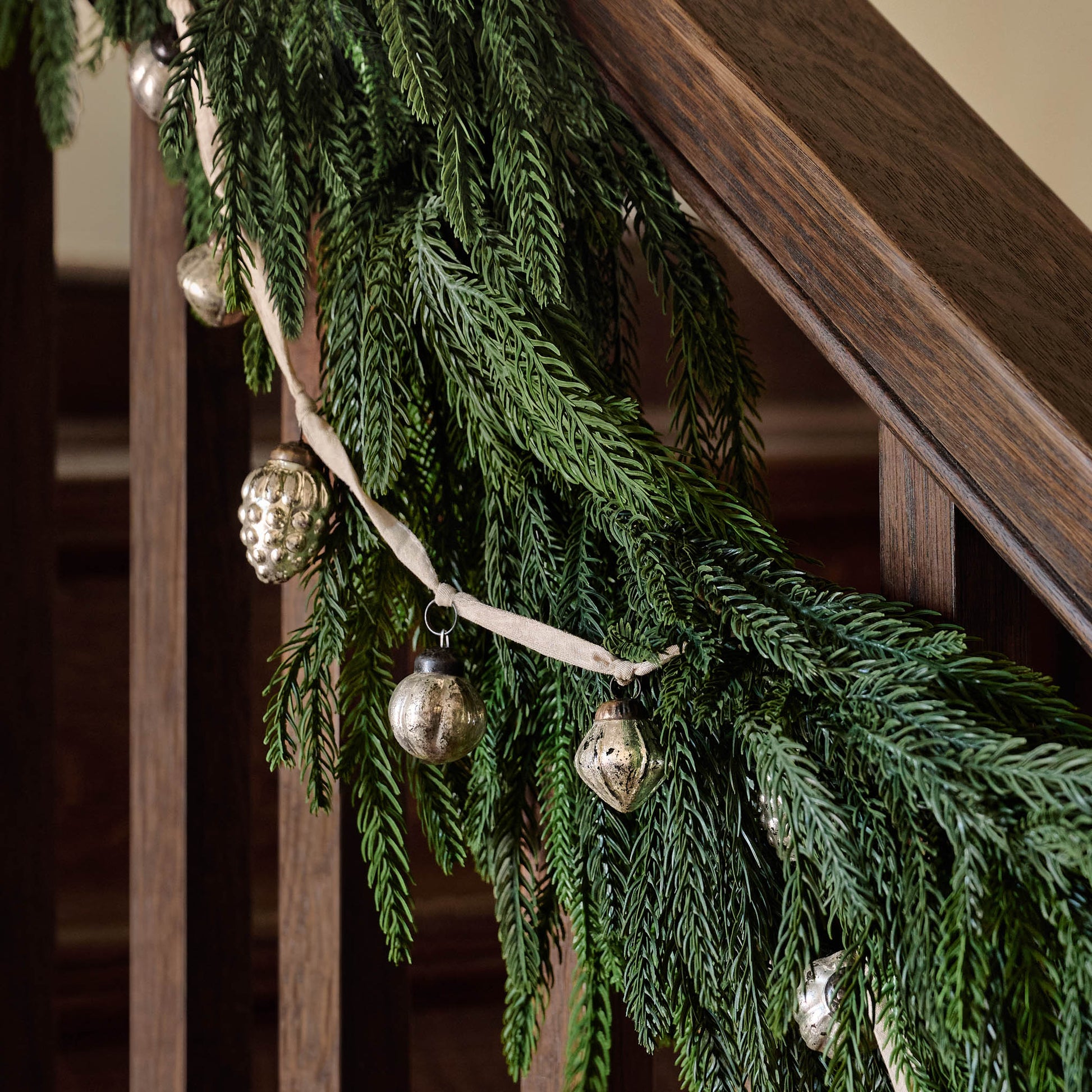Real Touch Norfolk Pine Garland on a stair rail