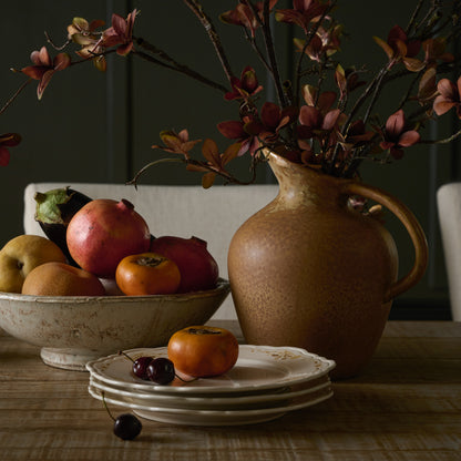 Rustic Cream Accent Bowl containing fruit on a table