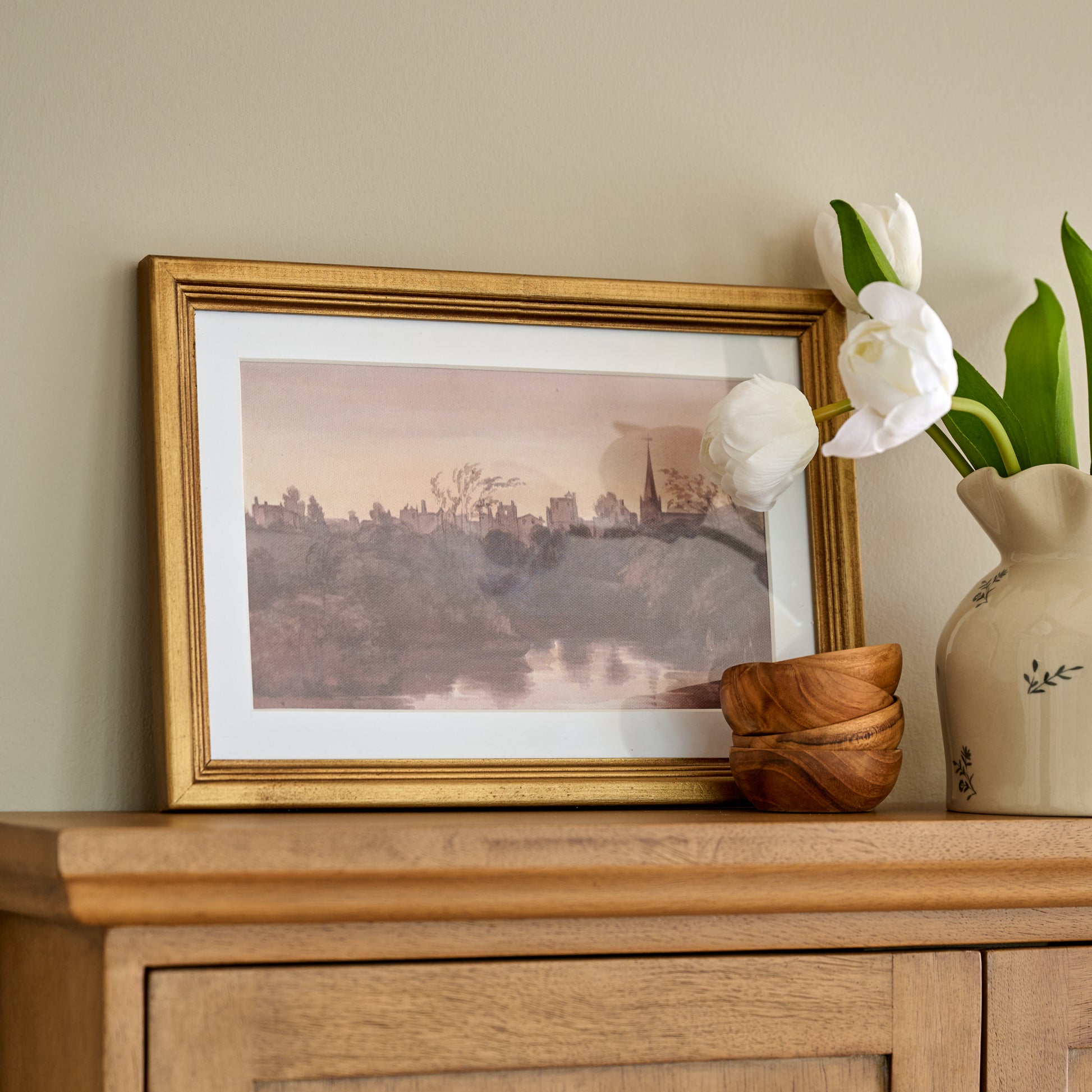 Steeple On the Water Framed Print styled above sideboard with mini bowls and floral vase