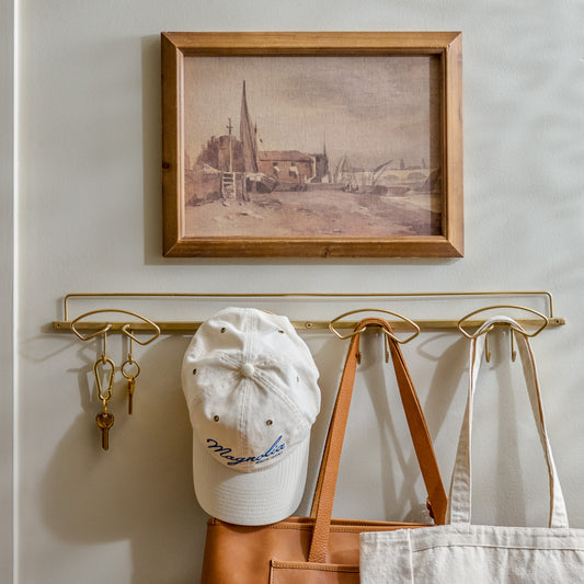 Seaside Village styled on the wall above brass wall hooks 